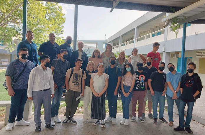 group photo of students and teachers in front of a courtyard at a school